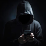 Faceless Man Wearing Hoodie In Dark Room On Smartphone, Cybercrime And Online Fraud Concept Backgrounds. Generative AI.